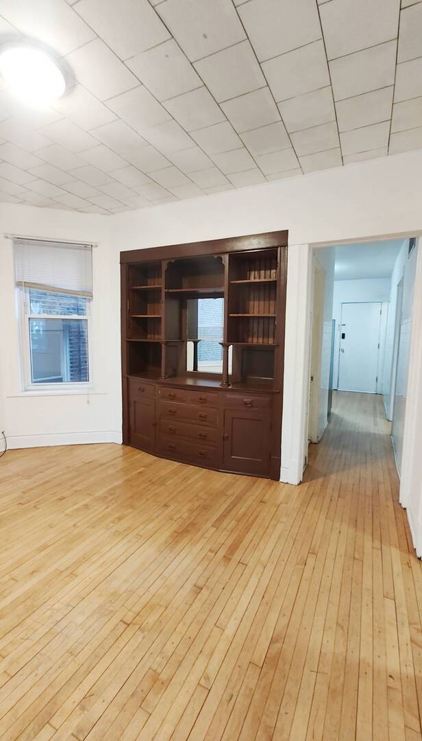 3137 West 42nd Street, Unit 1 Chicago, IL 60632 - Photo 3 of 7 a view of an empty room with a fireplace and a window