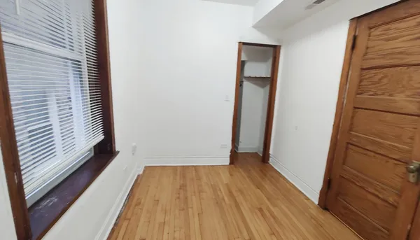 a view of a hallway with wooden floor and a window