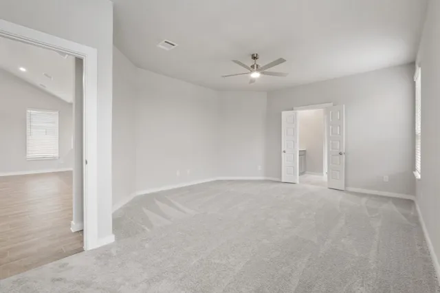 an empty room with fan and a ceiling fan