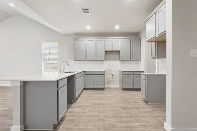 a kitchen with a white stove top oven sink and cabinets