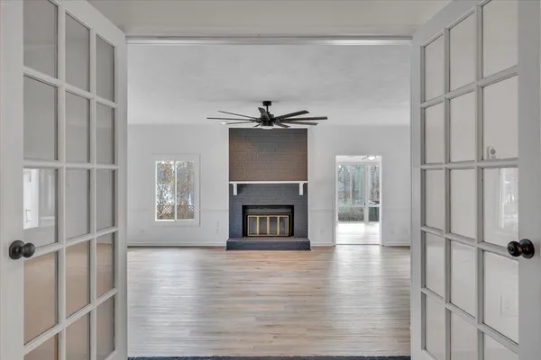 a view of a livingroom with a chandelier fan and windows