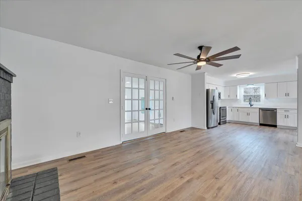 a kitchen with a refrigerator a sink and dishwasher with wooden floor