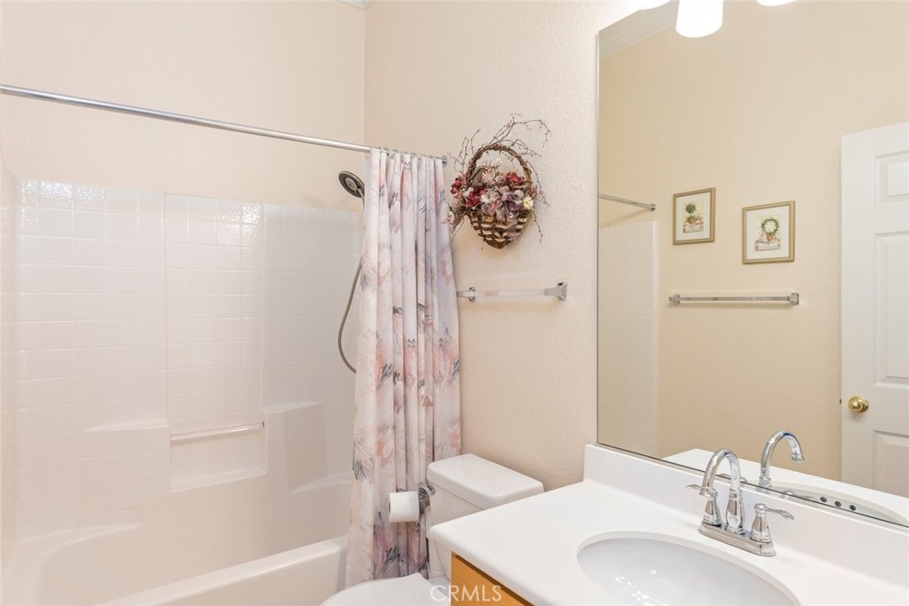 29546 Winding Brook Drive Menifee, CA 92584 - Photo 8 of 21 a bathroom with a white bath tub sitting next to a white sink and a shower