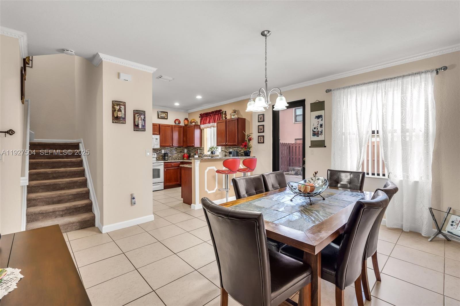 7161 Southwest 163rd Place Miami, FL 33193 - Photo 7 of 39 a view of a dining room and livingroom with furniture wooden floor a chandelier
