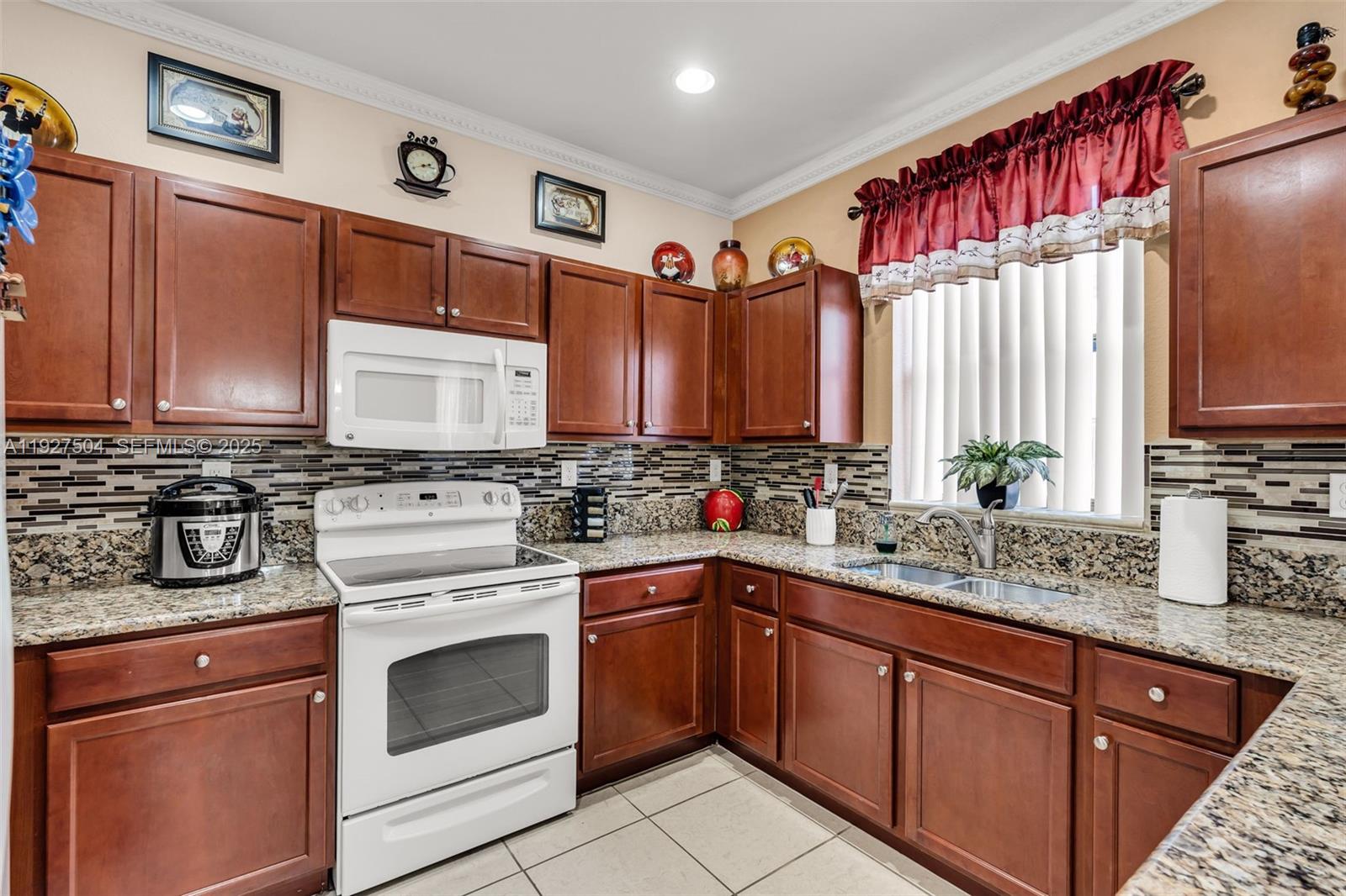 7161 Southwest 163rd Place Miami, FL 33193 - Photo 10 of 39 a kitchen with a sink stove and cabinets