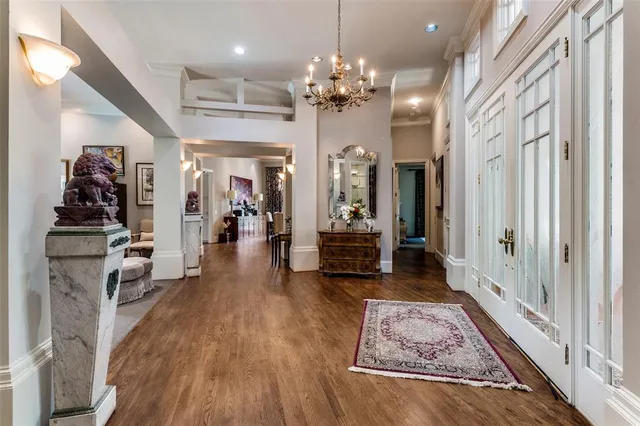 a view of a hallway with wooden floor and a chandelier