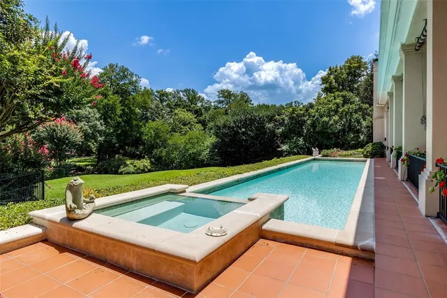 a view of a pool with a bench and a garden