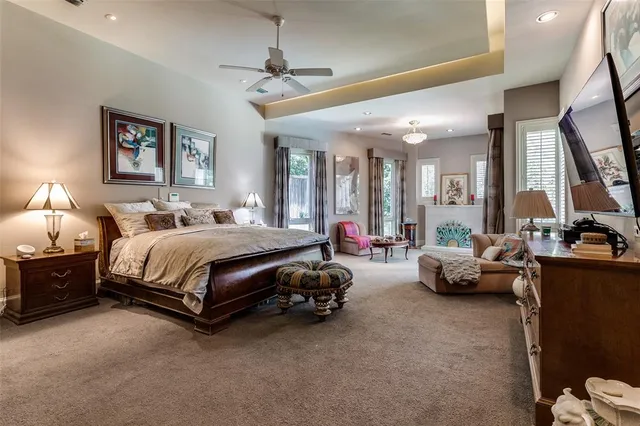 a bedroom with a bed couch chandelier and a window