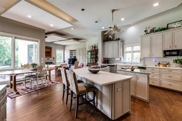 a large kitchen with kitchen island a island a sink a stove and wooden floors