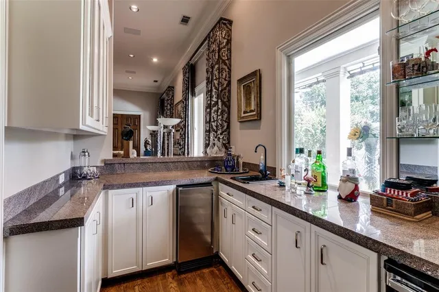 a kitchen with stainless steel appliances granite countertop a sink a stove and a wooden floor