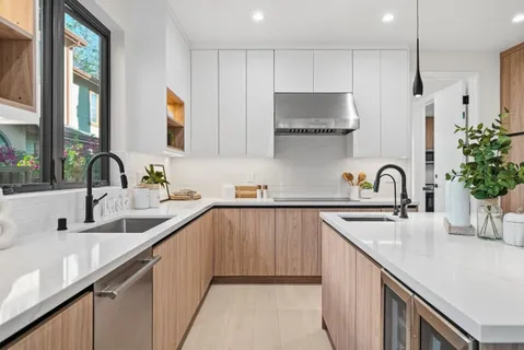 a kitchen with kitchen island a sink cabinets a stove and a window