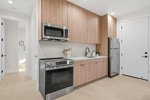 a kitchen with stainless steel appliances granite countertop a stove a microwave and a refrigerator