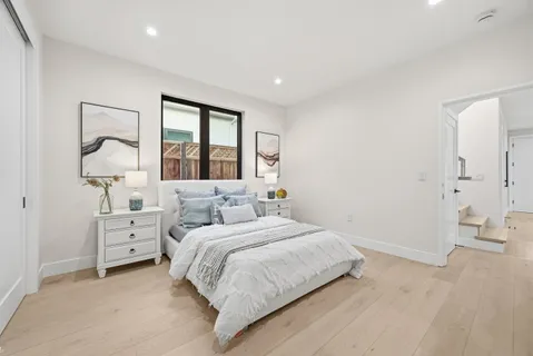 a bedroom with a white bed and white walls