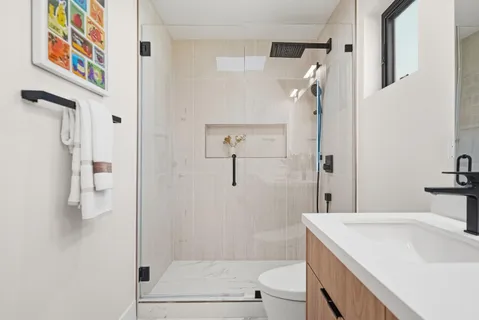 a bathroom with a sink a toilet and shower