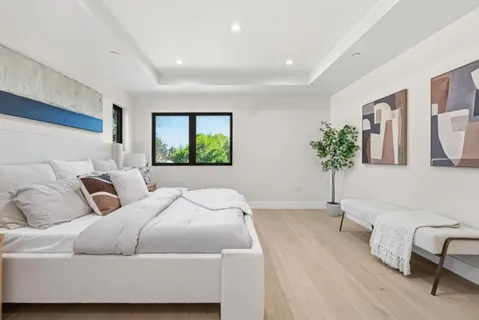 a bedroom with a large bed and a potted plant