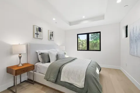 a bedroom with a bed and a lamp on dresser