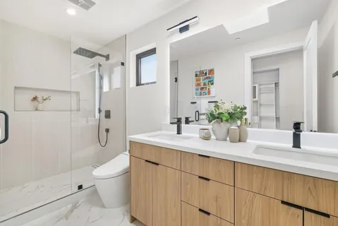 a bathroom with a granite countertop sink a toilet and shower