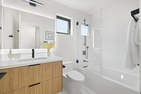 a bathroom with a granite countertop sink toilet and shower