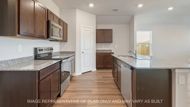 a kitchen with stainless steel appliances granite countertop a stove a sink and a refrigerator