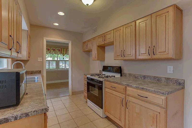 4974 Princeton Road Memphis, TN 38117 - Photo 3 of 10 Kitchen featuring gas range, black microwave, light tile patterned flooring, recessed lighting, and light brown cabinets