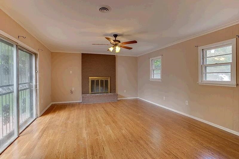 4974 Princeton Road Memphis, TN 38117 - Photo 7 of 10 Unfurnished living room with ornamental molding, light wood finished floors, a fireplace, and a ceiling fan
