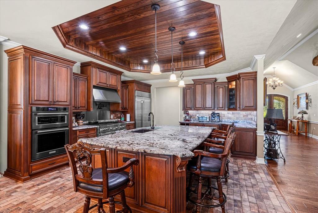 4107 Southwest State Road 45 Newberry, FL 32669 - Photo 31 of 100 a kitchen with stainless steel appliances granite countertop a stove top oven a sink a dining table and chairs with wooden floor