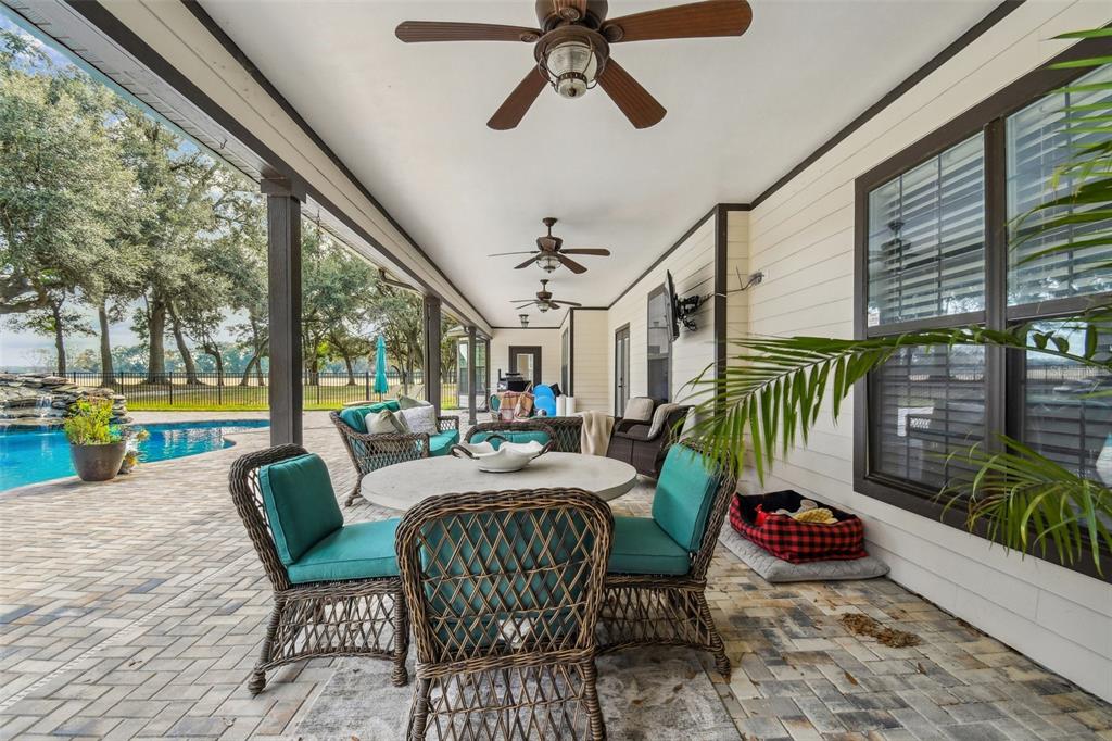 4107 Southwest State Road 45 Newberry, FL 32669 - Photo 79 of 100 a view of a patio with a dining table chairs and a floor to ceiling window