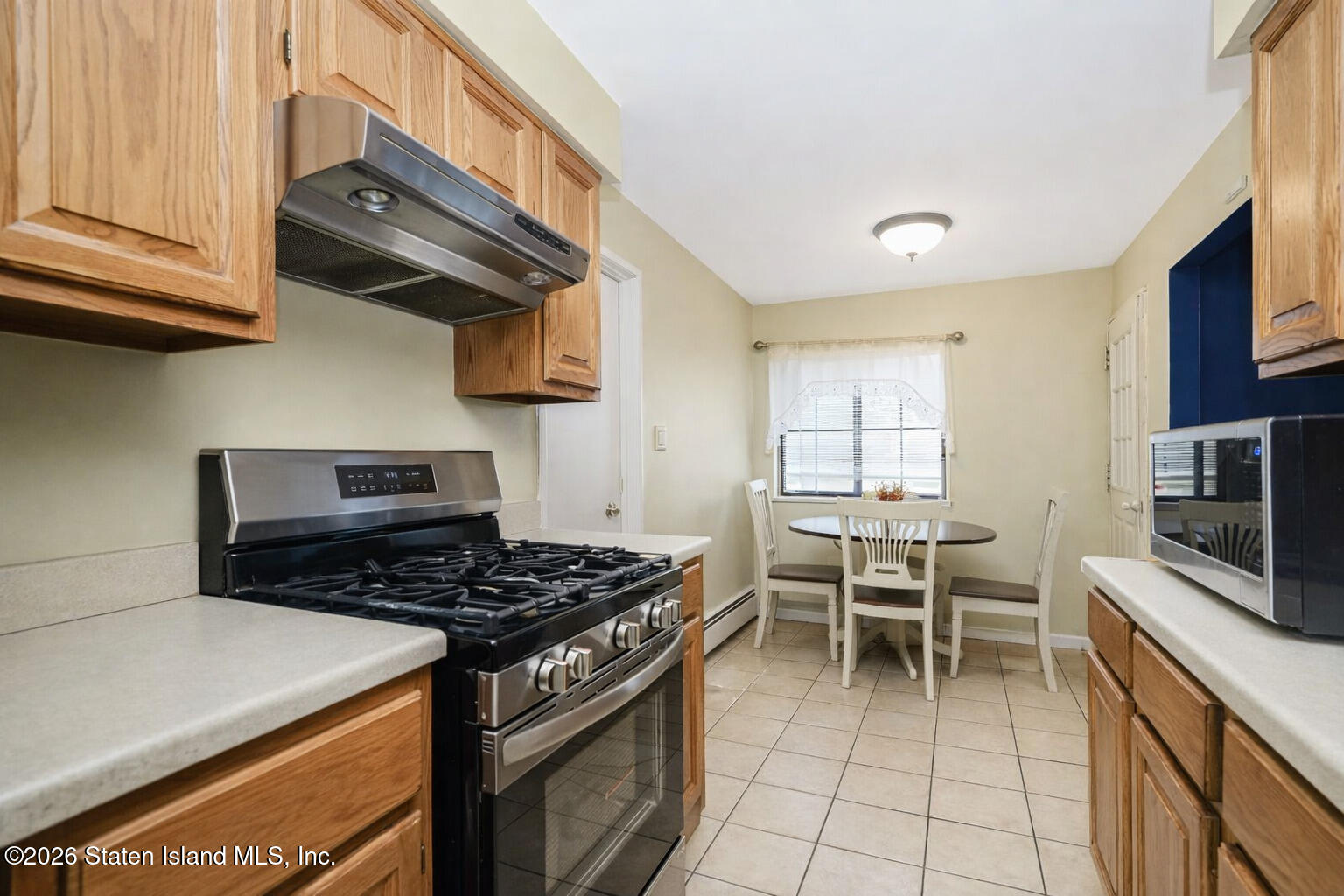 120 Devon Loop, Unit 6 Staten Island, NY 10314 - Photo 6 of 19 a kitchen with stainless steel appliances granite countertop a stove a sink and a microwave