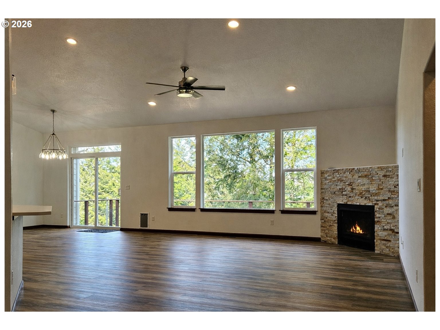 98205 Sunforest Court Brookings, OR 97415 - Photo 12 of 45 a view of an empty room with wooden floor and a fireplace
