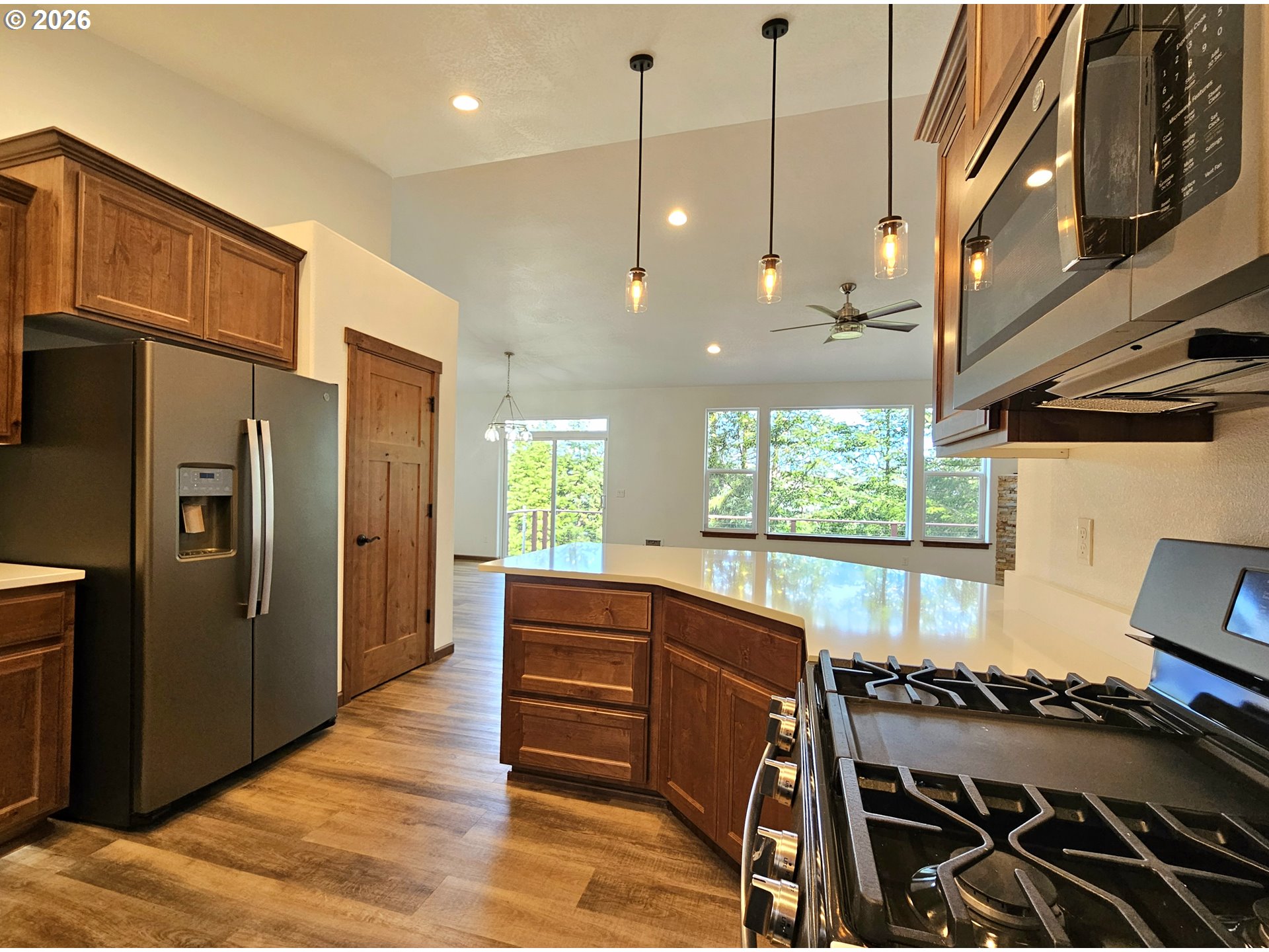 98205 Sunforest Court Brookings, OR 97415 - Photo 18 of 45 a kitchen with stainless steel appliances granite countertop a stove a refrigerator and a wooden cabinets