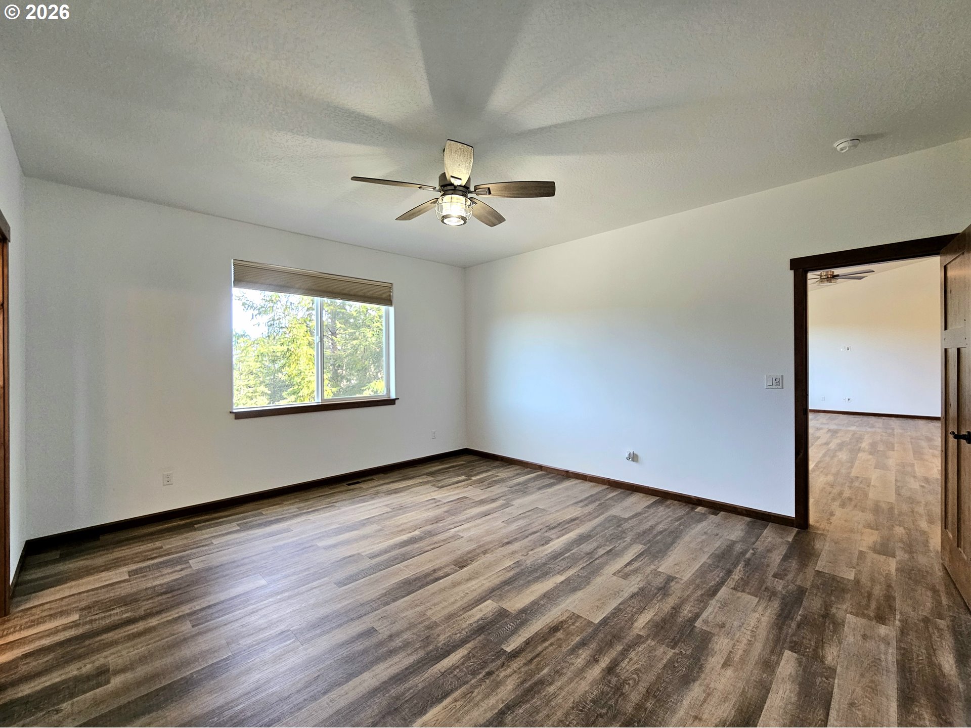 98205 Sunforest Court Brookings, OR 97415 - Photo 20 of 45 an empty room with wooden floor chandelier fan and windows