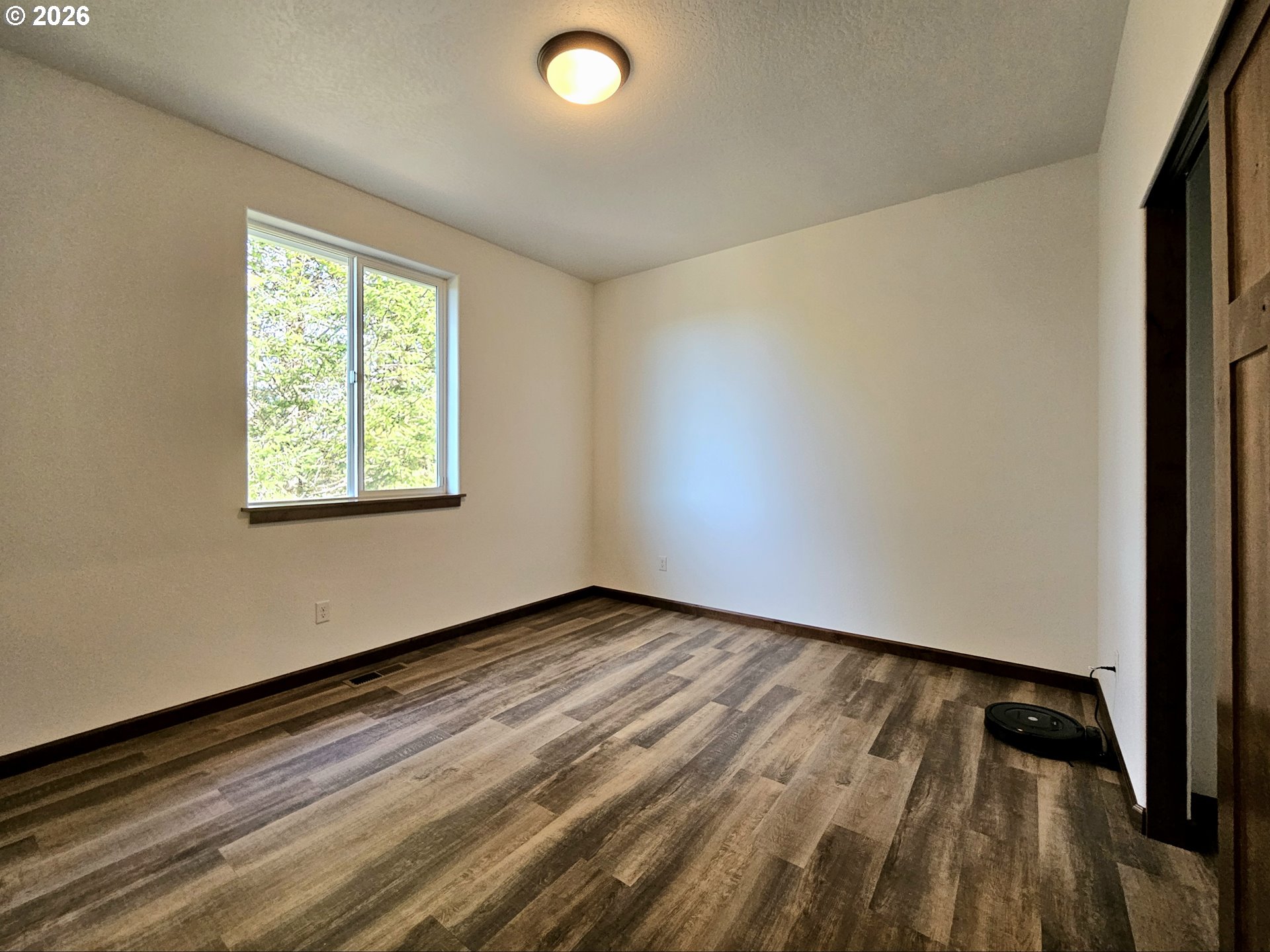 98205 Sunforest Court Brookings, OR 97415 - Photo 30 of 45 a view of an empty room with wooden floor and a window