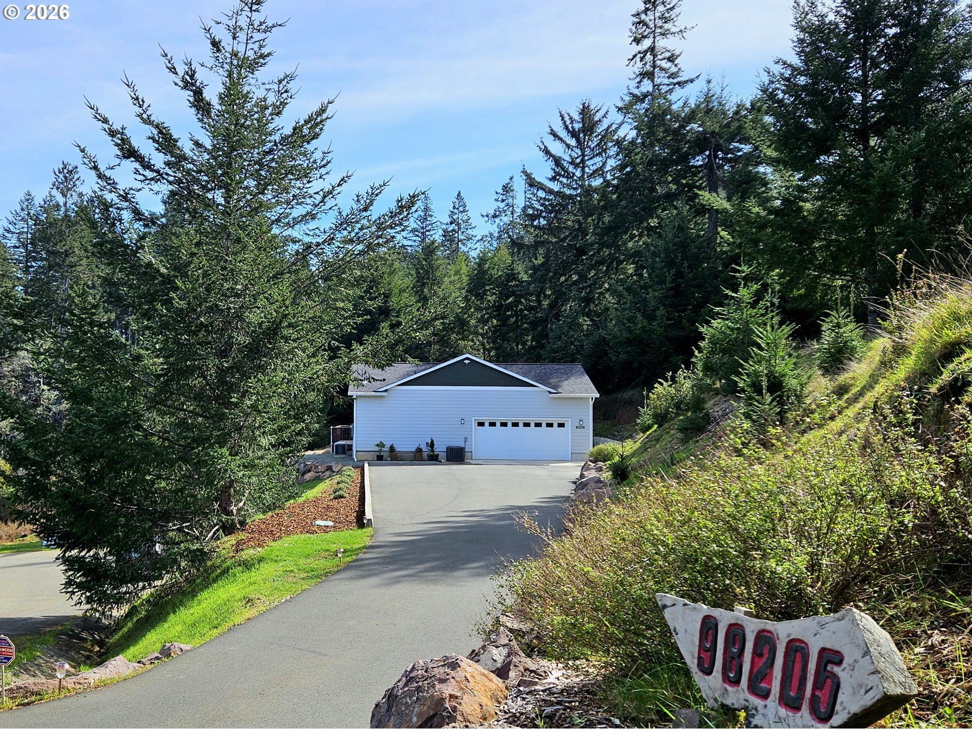 98205 Sunforest Court Brookings, OR 97415 - Photo 5 of 45 a front view of a house with a yard and garage
