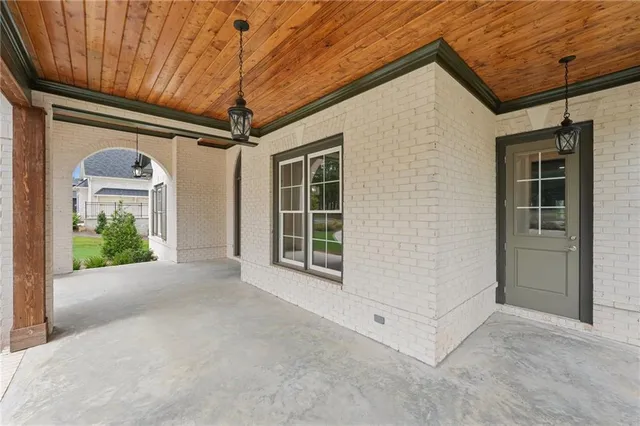 a view of a big room with wooden floor chandeliers and kitchen view