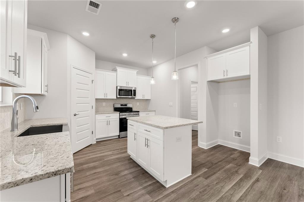 478 Magnolia Grove Place Cornelia, GA 30531 - Photo 14 of 38 a kitchen with white cabinets and stainless steel appliances