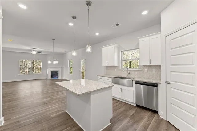 a large kitchen with stainless steel appliances lots of counter space and wooden floor
