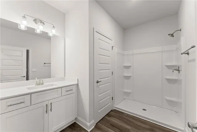 a bathroom with a double vanity sink a toilet and shower