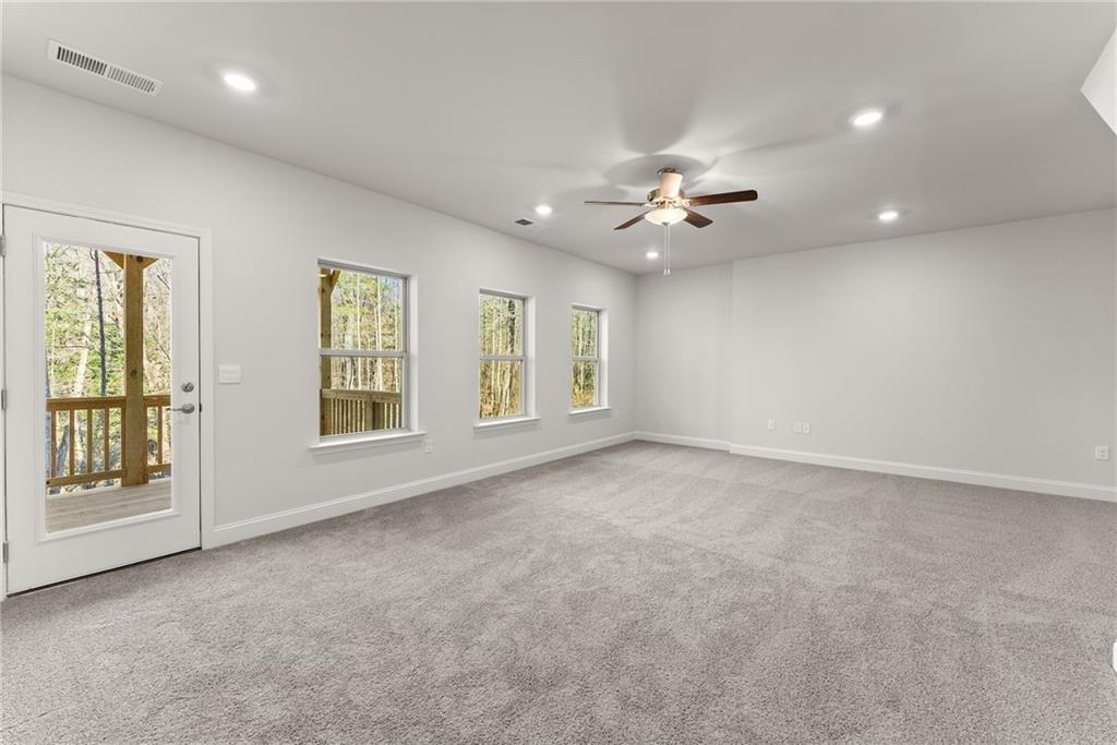 478 Magnolia Grove Place Cornelia, GA 30531 - Photo 20 of 38 an empty room with chandelier fan and windows