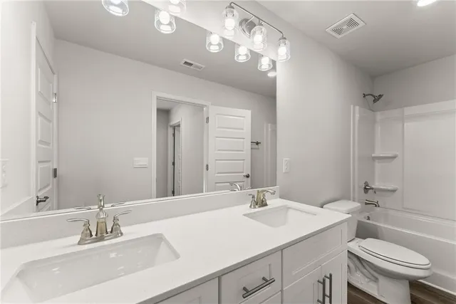a bathroom with a sink double vanity and a toilet