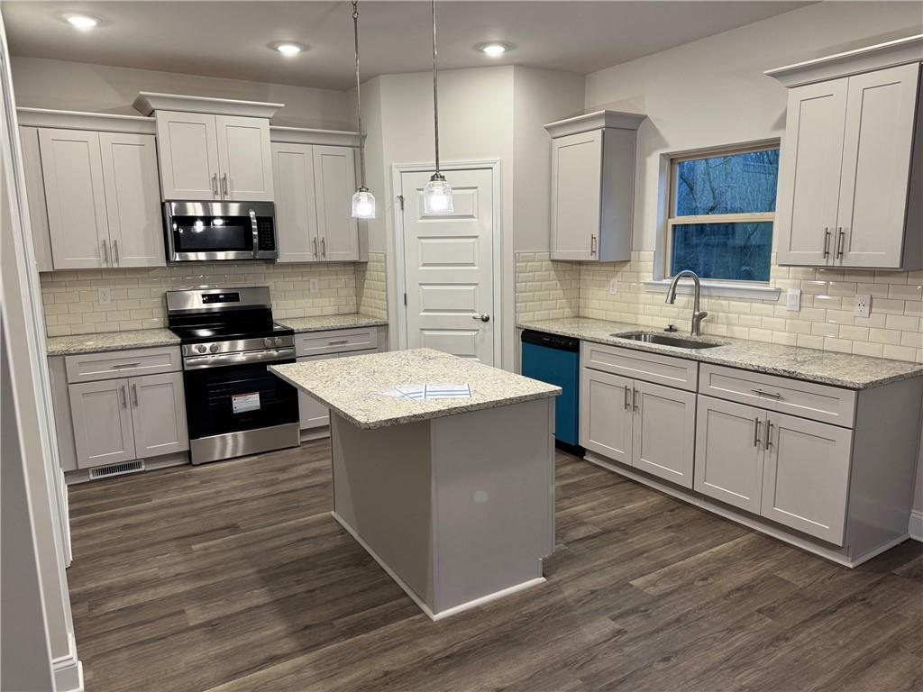 478 Magnolia Grove Place Cornelia, GA 30531 - Photo 3 of 38 a kitchen with stainless steel appliances kitchen island granite countertop a stove a sink and a refrigerator