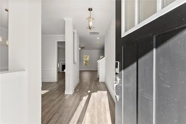 a view of a hallway with wooden floor and staircase