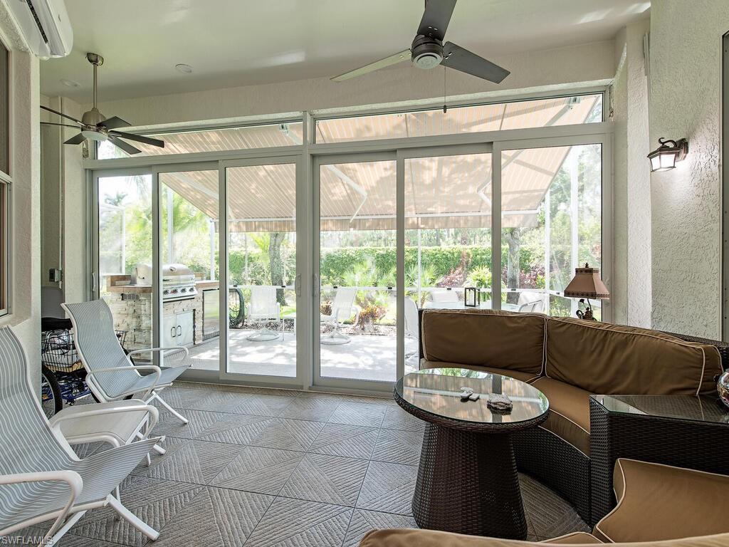 901 Marblehead Drive, Unit B1 Naples, FL 34104 - Photo 12 of 13 a living room with furniture and a floor to ceiling window