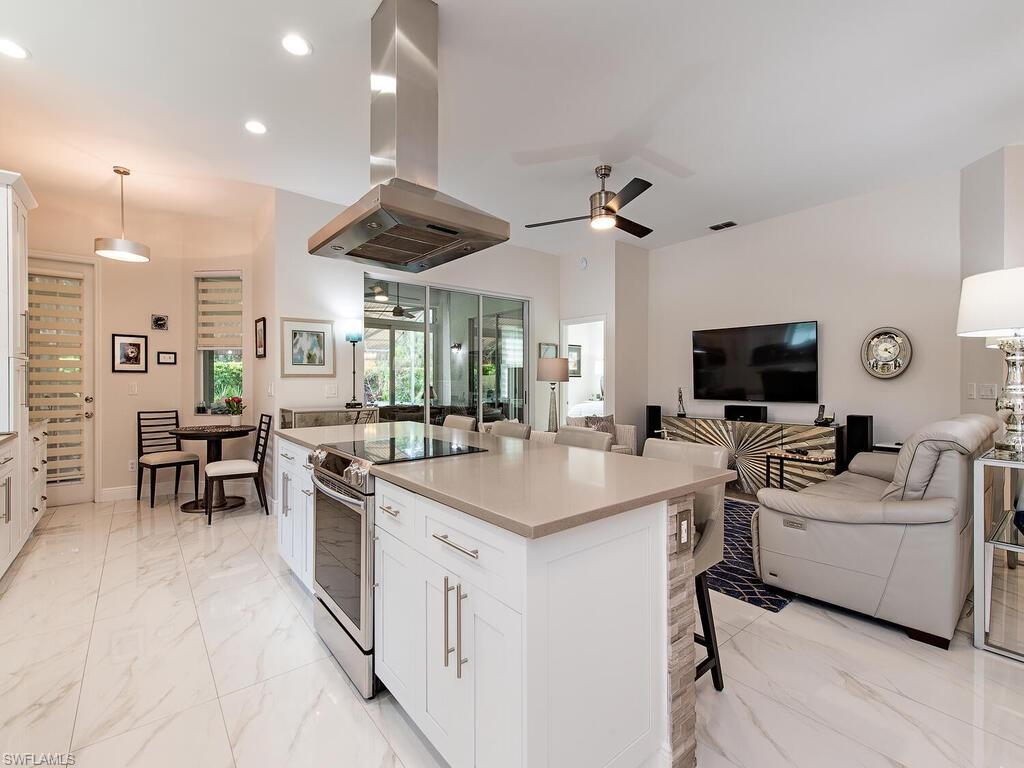 901 Marblehead Drive, Unit B1 Naples, FL 34104 - Photo 2 of 13 a living room with furniture a flat screen tv and kitchen view