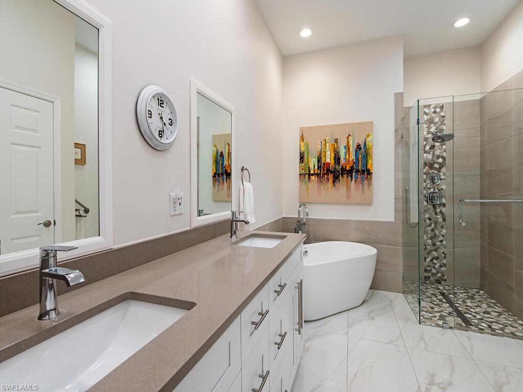 901 Marblehead Drive, Unit B1 Naples, FL 34104 - Photo 7 of 13 a spacious bathroom with a tub sink and mirror