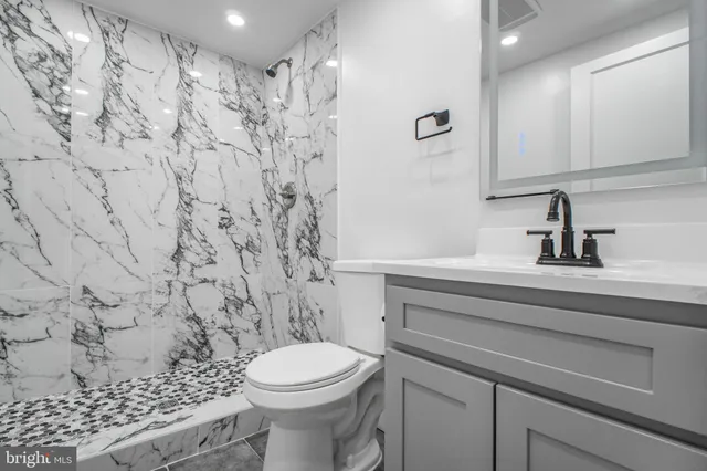 a bathroom with a sink a toilet and shower