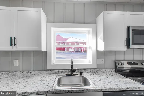 a kitchen with stainless steel appliances granite countertop a sink a refrigerator and a stove