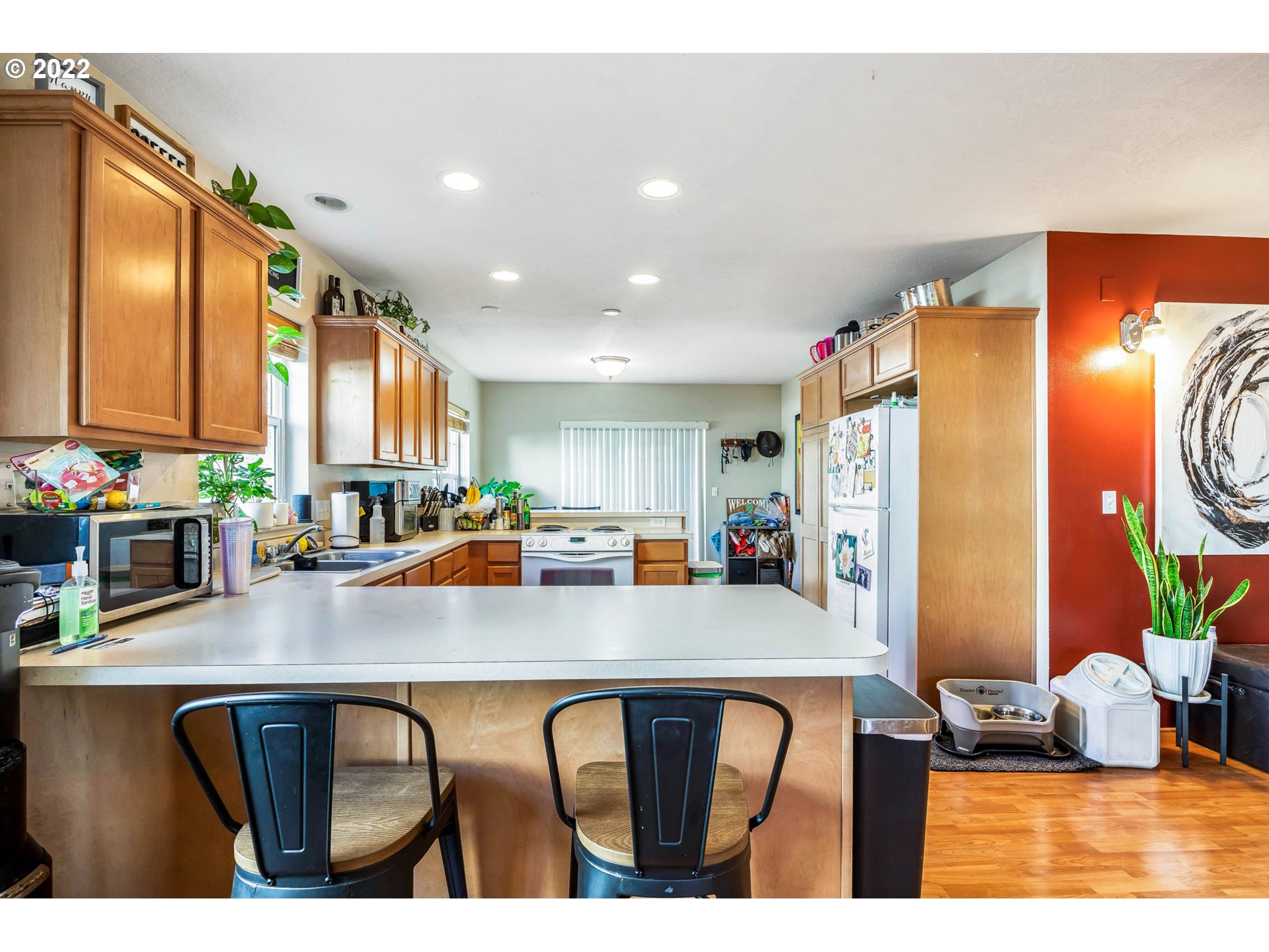 1849 8th Street Springfield, OR 97477 - Photo 10 of 32 a kitchen with stainless steel appliances granite countertop a refrigerator a sink a stove a dining table and chairs with wooden floor