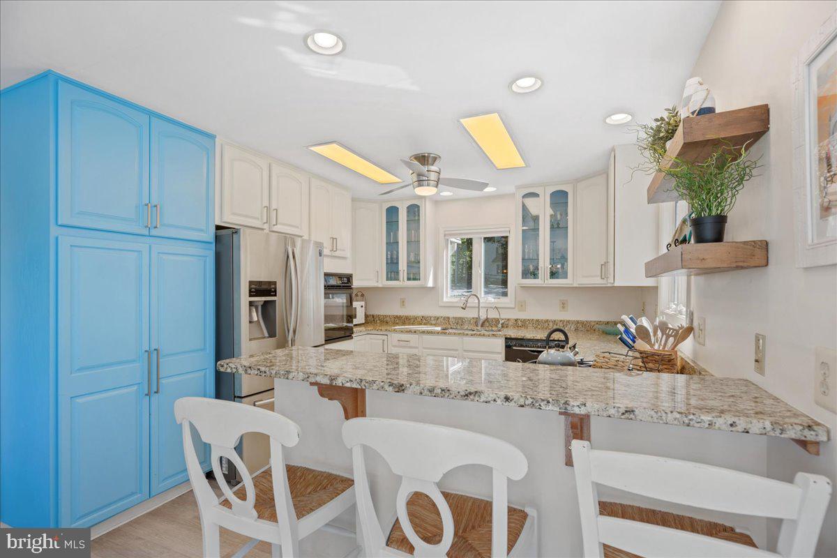 219 Calvert Drive Lusby, MD 20657 - Photo 11 of 51 a kitchen with kitchen island granite countertop a sink cabinets and stainless steel appliances