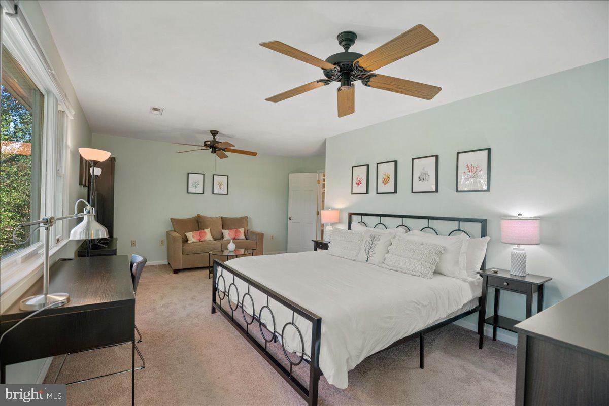 219 Calvert Drive Lusby, MD 20657 - Photo 25 of 51 a bedroom with a bed and a chandelier