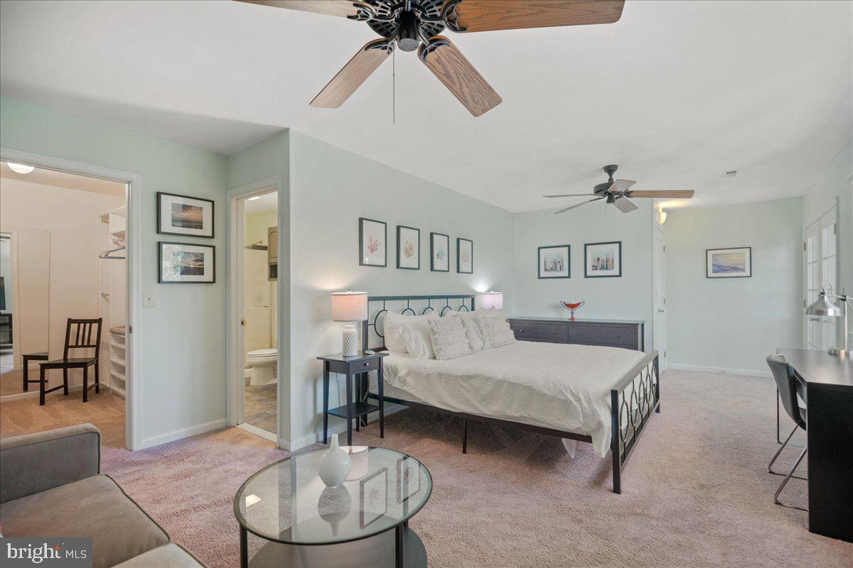 219 Calvert Drive Lusby, MD 20657 - Photo 30 of 51 a bedroom with a bed and a chandelier